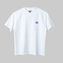 Load image into Gallery viewer, White t-shirt with a small logo on a light beige background