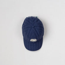 Load image into Gallery viewer, A navy blue baseball cap with thin white pinstripes and a white embroidered lotus flower on the front, displayed against a light gray background.