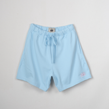 Load image into Gallery viewer, Light blue drawstring shorts with a small pink embroidered logo on the lower left hem, displayed flat against a light gray background.