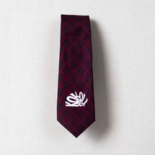 Load image into Gallery viewer, Maroon plaid tie with a white logo on a light gray background
