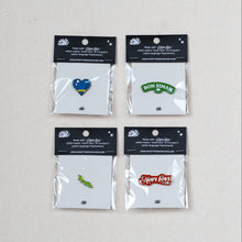 Load image into Gallery viewer, Four small enamel pin packages arranged in a 2x2 grid on a light beige surface. Each pin is sealed in a clear plastic bag with a black header card.

